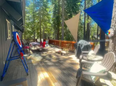 a deck with chairs and a table and an umbrella at Moose Haven - Family Favorite! Close to beaches! in South Lake Tahoe