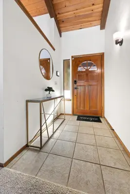a hallway with a table and a wooden door at Sequoia Zen River House in Three Rivers
