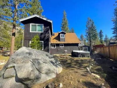 a house with a large rock in front of it at Panorama Chalet - Hot tub - Pool Table - Snow in Nebelhorn