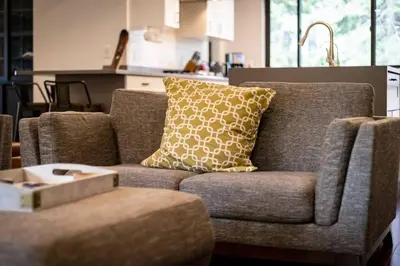 a living room with a couch with a pillow on it at Mountain Pine Memories - Dogs - Hot tub - E-bikes in South Lake Tahoe