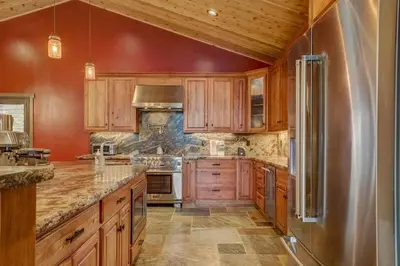 a kitchen with wooden cabinets and a stainless steel refrigerator at Chateau de Navahoe - Luxury - Hot tub - Large yard in South Lake Tahoe