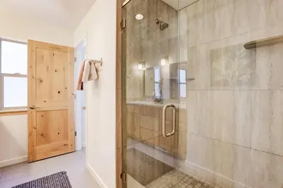 a bathroom with a shower with a glass door at Sierra Solace - Forest & Seasonal River Out Back in South Lake Tahoe