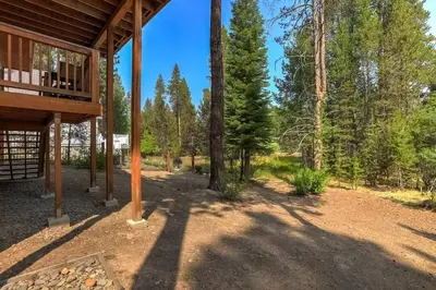 a view of a porch of a house in the woods at Sierra Solace - Forest & Seasonal River Out Back in South Lake Tahoe
