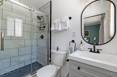 a bathroom with a toilet and a sink and a mirror at Guadalupe Getaway - Pets - Hot Tub - AC in South Lake Tahoe