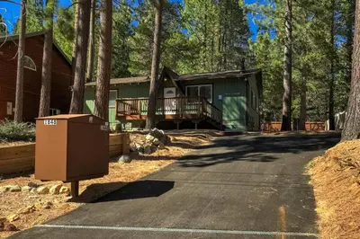 a house in the woods with a trash can in the driveway at Bear Cub Cabin - Pets - Hot tub - Arcade Game in Mevers