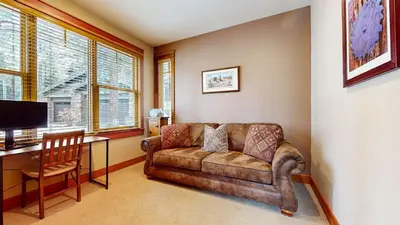 a living room with a couch and a desk with a computer at Timbers #27 townhouse in Mammoth Lakes