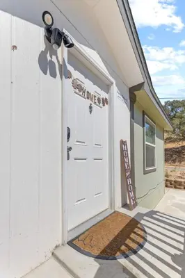 a white garage door with a welcome sign on it at 10 Min Drive to the Sequoias in Three Rivers