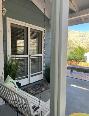 a porch swing on the front porch of a house at Mountain View Home in Kernville