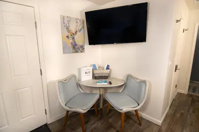 a room with a table and two chairs and a flat screen tv at Creature Comforts Suite-Private Hot Tub-Sleeps 2 in Ahwahnee