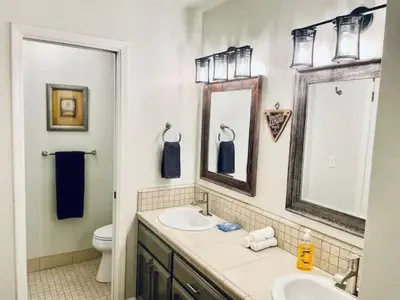 a bathroom with a sink and a toilet and a mirror at Creature Comforts Suite-Private Hot Tub-Sleeps 2 in Ahwahnee