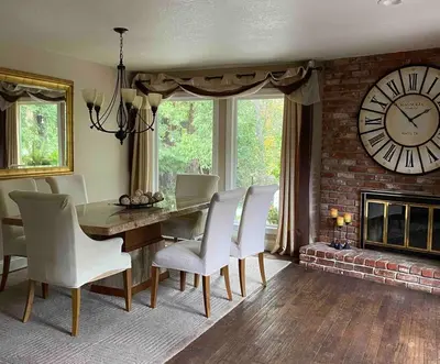 a dining room with a table and chairs and a large clock at Redwood Garden in Sacramento