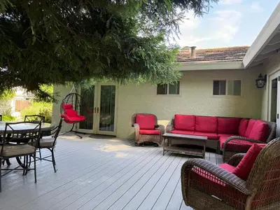 a patio with a red couch and a table and chairs at Redwood Garden in Sacramento