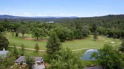 an aerial view of a golf course with a pond at Peaceful Creekside Buddha Retreat in Groveland