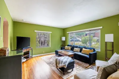 a living room with a couch and a tv at Cozy 2BR Home Near UNR with Large Deck & Parking in Reno