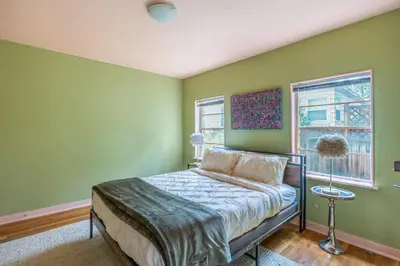 a bedroom with green walls and a bed and a window at Cozy 2BR Home Near UNR with Large Deck & Parking in Reno
