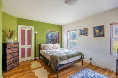 a bedroom with green and white walls and a bed at Cozy 2BR Home Near UNR with Large Deck & Parking in Reno