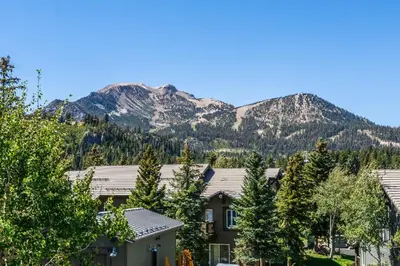 a house with a mountain in the background at Snowcreek #793 Phase V - 3 Bedroom 3 Bath Sleeps 8 with Private 1 Car Garage in Mammoth Lakes