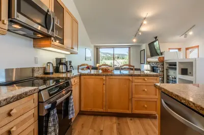 a kitchen with wooden cabinets and a large window at Snowcreek #793 Phase V - 3 Bedroom 3 Bath Sleeps 8 with Private 1 Car Garage in Mammoth Lakes