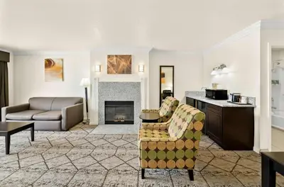 a living room with a couch and a fireplace at Best Western Executive Inn in Los Banos
