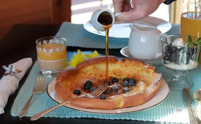 a person drizzling syrup on a cake on a table at Courtwood Inn in Murphys