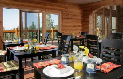 a dining room with tables and chairs in a cabin at Courtwood Inn in Murphys