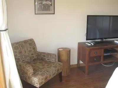 a living room with a chair and a flat screen tv at Courtwood Inn in Murphys
