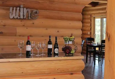 a bar in a log cabin with wine bottles and glasses at Courtwood Inn in Murphys