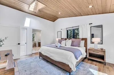 a bedroom with a large bed and a wooden ceiling at Modern Mountain Luxury Retreat, Hot Tub & Grill in Carnelian Bay