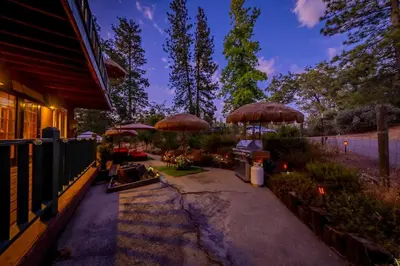 a patio with umbrellas on top of a house at Sunset Summit Villa 2 min from Bass Lake in Bass Lake
