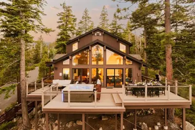 a house in the woods with a lot of windows at Alpenglow Aerie - StayLuxe Rubicon in Meeks Bay