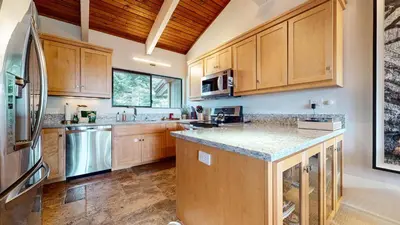 a kitchen with wooden cabinets and granite counter tops at Mammoth Point #117 condo in Mammoth Lakes
