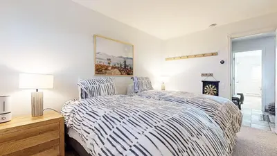 a bedroom with a bed with a striped comforter at Mammoth Point #117 condo in Mammoth Lakes