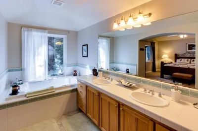 a bathroom with two sinks and a tub and a large mirror at The Gathering Place in Truckee