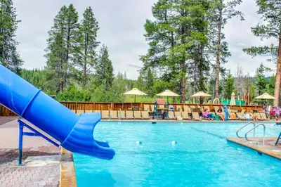 a pool with a blue slide in a resort at The Gathering Place in Truckee