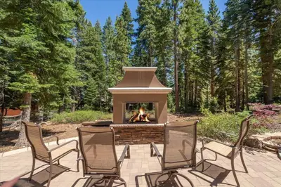 a fire pit with three chairs and a fireplace at Cozy and central Tahoe cabin with private hot-tub outdoor fireplaces close to slopes in Ridgewood