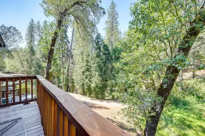 a deck with a view of the woods at Mtn-View Gem Deck, Grill and Fire Pit in West Point in Volcano