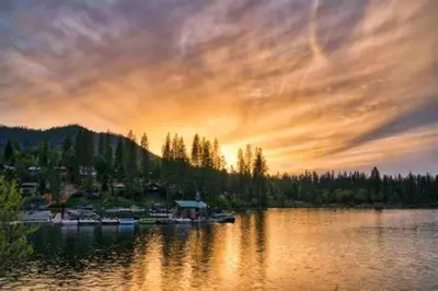 a sunset over a lake with boats on the water at Walnut Grove 2BD 1Bath in Oakhurst