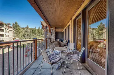 a balcony with a table and chairs on a porch at Big Horn Lodge 307 by East West Hospitality in Truckee