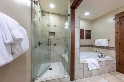 a bathroom with a shower and a bath tub at Big Horn Lodge 307 by East West Hospitality in Truckee