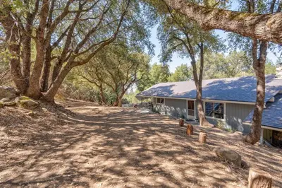 a house with a lot of trees in front of it at Bald Bear Barracks in Mariposa