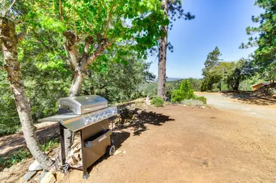 a grill sitting on a dirt road next to trees at Sonora Hilltop Home Scenic Views, Pet Friendly! in Sonora