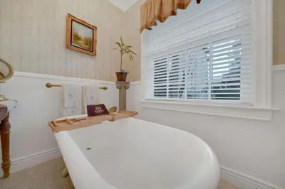 a white bath tub in a bathroom with a window at Timeless Victorian Gem w Breathtaking Mountains in Sutter Creek