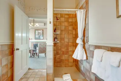 a bathroom with a shower with a tiled wall at Romantic Victorian Getaway The Garden in Sutter Creek