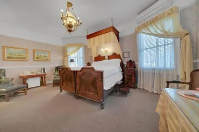 a bedroom with a large bed and a chandelier at Romantic Victorian Getaway The Blue Room in Sutter Creek