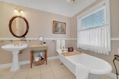 a bathroom with a tub and a sink and a mirror at Romantic Victorian Getaway The Blue Room in Sutter Creek