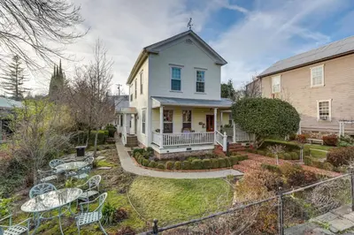 a white house with a yard with tables and chairs at Romantic Victorian Getaway The Hideaway in Sutter Creek