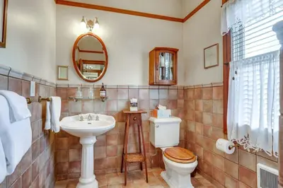 a bathroom with a toilet and a sink and a mirror at Romantic Victorian Getaway The Fox in Sutter Creek