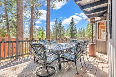 a patio with a table and chairs on a deck at Updated Tahoe Retreat Near Trails with Game Room in Kings Beach