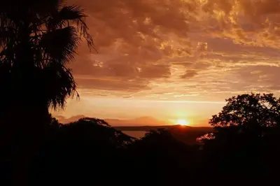 a sunset with the sun setting in the distance at Lakeview Dome in La Grange