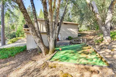 a yard of a house with a putting green at 1 Mi to Pine Mountain Lake Marina Yosemite Cabin! in Groveland